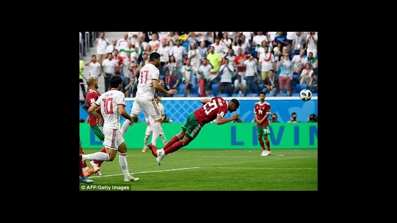 Cầu thủ Ma Rốc vươn vai vượt qua cầu thủ Oman trong trận đấu bóng đá quốc tế.